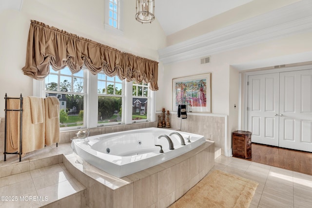 bathroom with tile patterned flooring, a tub with jets, and high vaulted ceiling