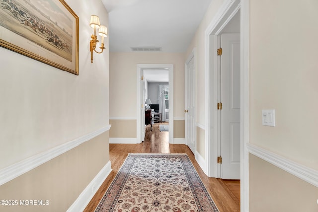 hall with wood finished floors and baseboards
