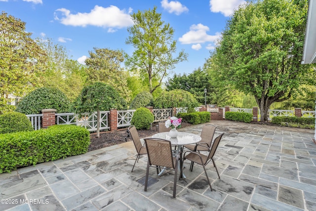 view of patio with outdoor dining space and view of scattered trees