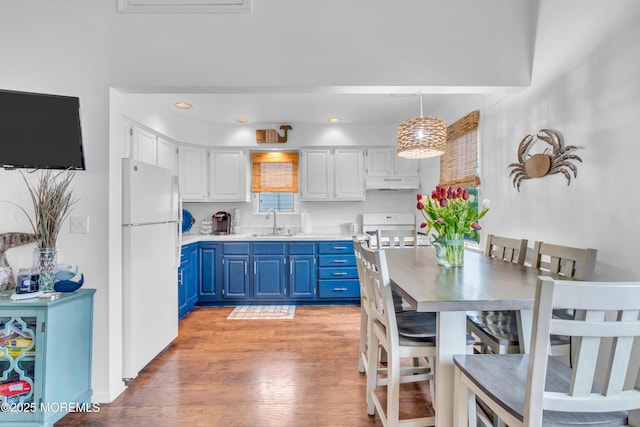233 Harbor Dr, Lavallette, NJ 08735 - kitchen with blue cabinets, freestanding refrigerator, under cabinet range hood, a sink, and light wood-style floors