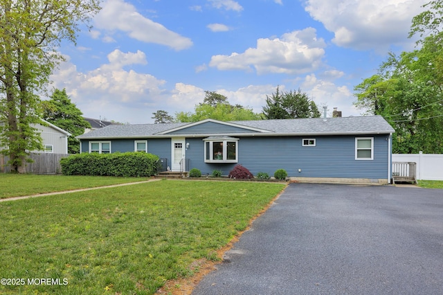 single story home with a chimney, a shingled roof, and driveway