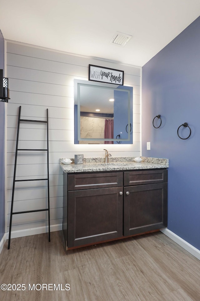 bathroom featuring baseboards, wood finished floors, and vanity