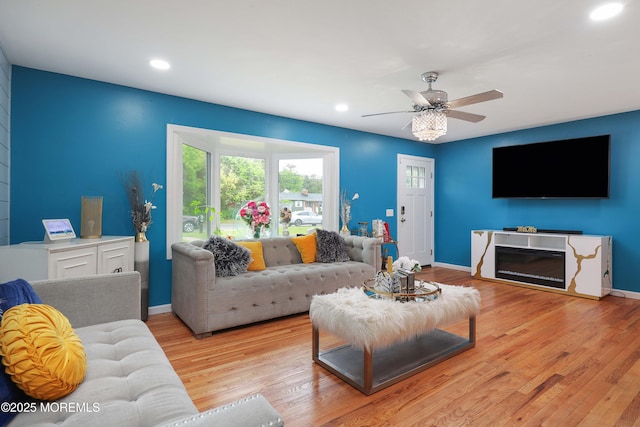 living room with recessed lighting, wood finished floors, ceiling fan, baseboards, and a fireplace