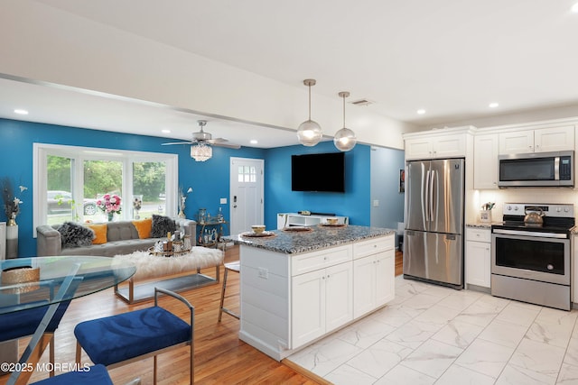 kitchen featuring appliances with stainless steel finishes, recessed lighting, white cabinetry, dark stone counters, and a ceiling fan