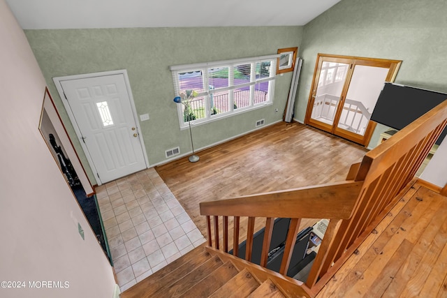 entryway featuring lofted ceiling, wood finished floors, stairs, and baseboards