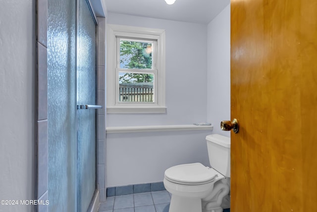 bathroom featuring tile patterned floors, an enclosed shower, and toilet