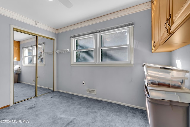 unfurnished bedroom with carpet, a closet, baseboards, and a ceiling fan