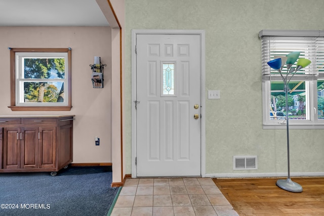 foyer entrance with baseboards and light tile patterned floors