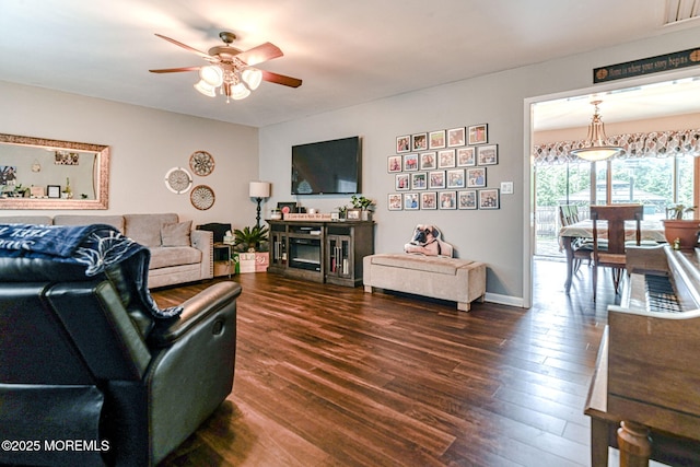living room with ceiling fan and dark wood finished floors