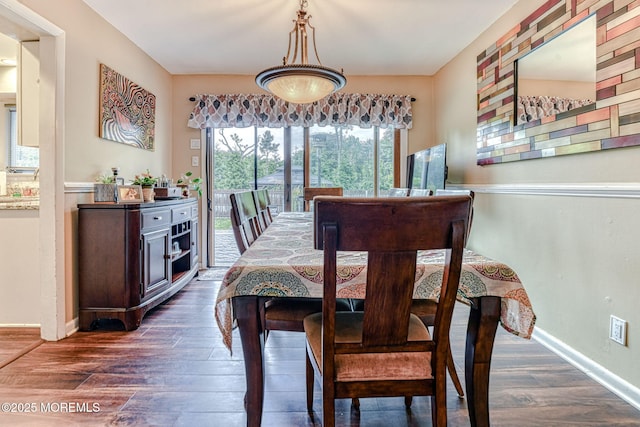 dining area featuring dark wood finished floors and baseboards