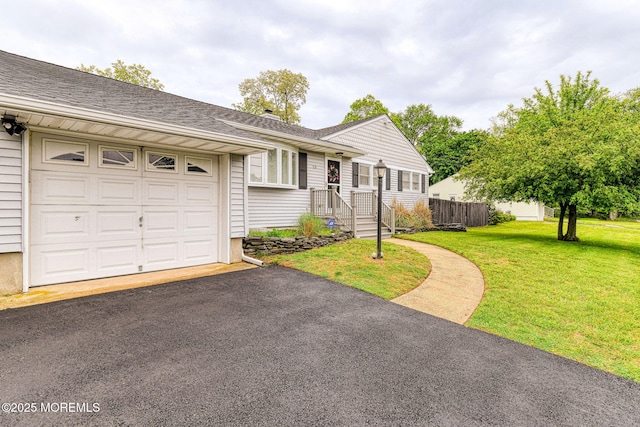 ranch-style house featuring a garage, roof with shingles, and asphalt driveway