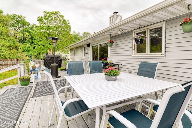 wooden deck with outdoor dining area and fence