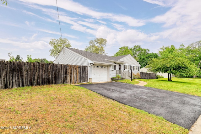 ranch-style house featuring a garage and asphalt driveway