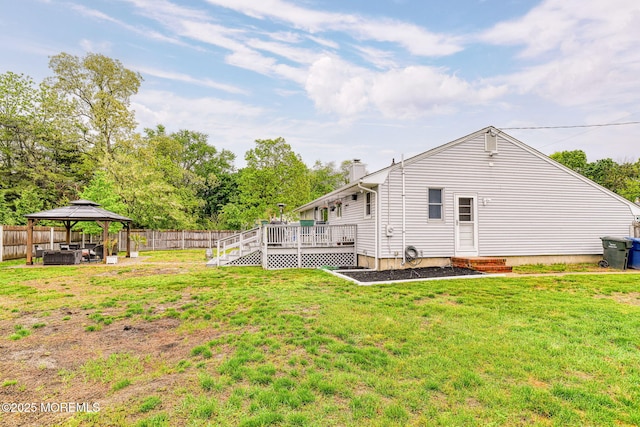 back of house with a gazebo, a chimney, and a wooden deck