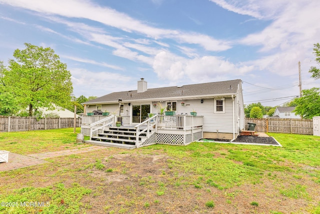 rear view of property with a deck, a chimney, a storage shed, and an outbuilding