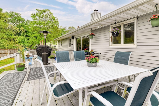 wooden deck with outdoor dining area and fence