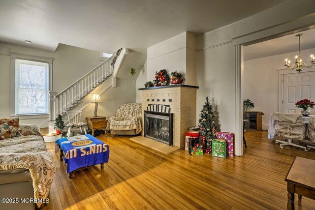 78 Navesink Ave, Highlands, NJ 07732 - living area featuring hardwood / wood-style floors, a chandelier, stairs, and a brick fireplace