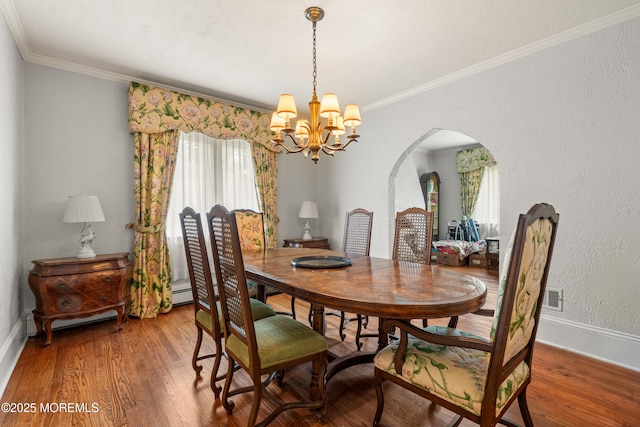 567 Deal Pkwy, Allenhurst, NJ 07711 - dining space featuring a chandelier, arched walkways, wood finished floors, ornamental molding, and baseboards