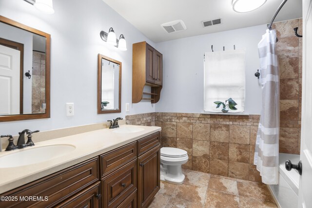 29 Jefferson Ct, Jackson, NJ 08527 - bathroom featuring toilet, stone finish floors, double vanity, tile walls, and a wainscoted wall