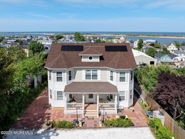 57 Shore Dr, Highlands, NJ 07732 - victorian home with a water view, a porch, roof mounted solar panels, and roof with shingles