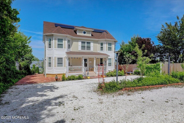 57 Shore Dr, Highlands, NJ 07732 - victorian-style house featuring roof mounted solar panels, a porch, and fence