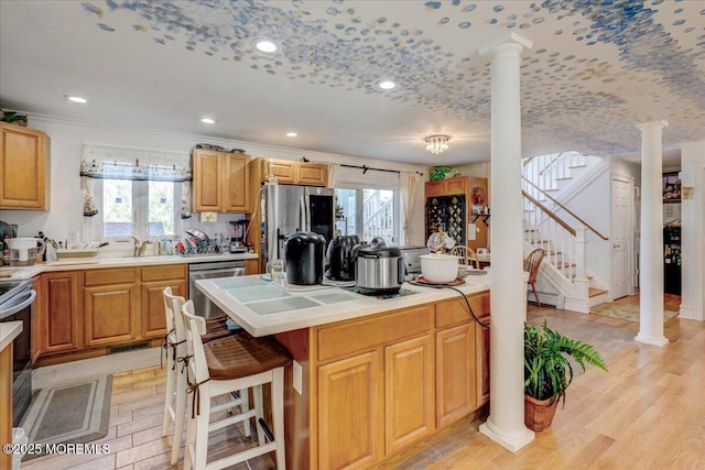 57 Shore Dr, Highlands, NJ 07732 - kitchen featuring decorative columns, light countertops, appliances with stainless steel finishes, a kitchen bar, and crown molding