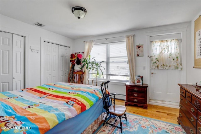 57 Shore Dr, Highlands, NJ 07732 - bedroom featuring multiple closets, baseboard heating, and light wood finished floors