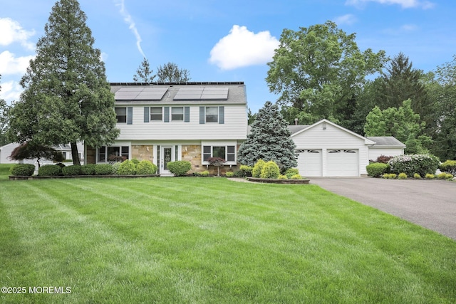 7 Colonial Ct, Manalapan, NJ 07726 - colonial house with solar panels, a front lawn, driveway, an attached garage, and stone siding