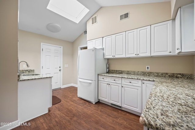 7 Colonial Ct, Manalapan, NJ 07726 - kitchen featuring freestanding refrigerator, a sink, a skylight, white cabinets, and dark wood-style floors