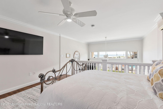 bedroom with ornamental molding, wood finished floors, and baseboards
