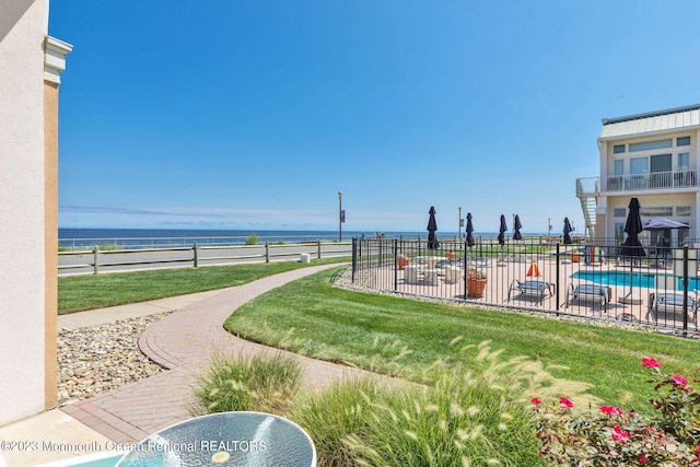 view of home's community featuring fence, a water view, and a pool