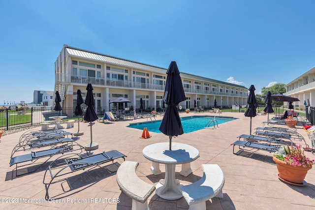 community pool with fence and a patio