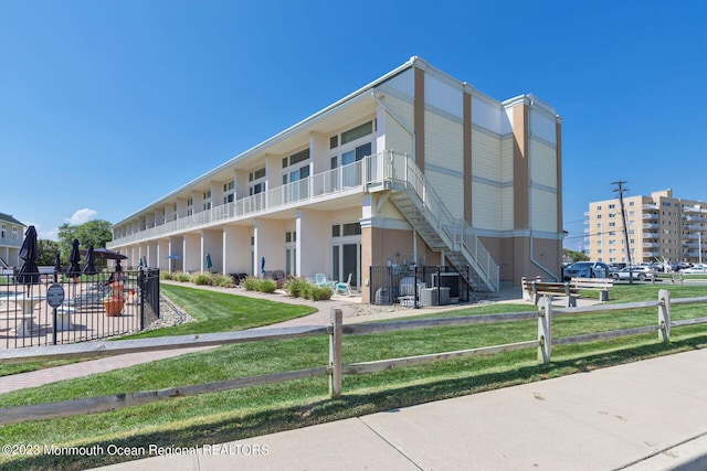 view of building exterior with fence and stairway