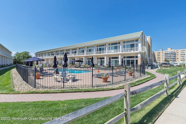 community pool with fence and a patio