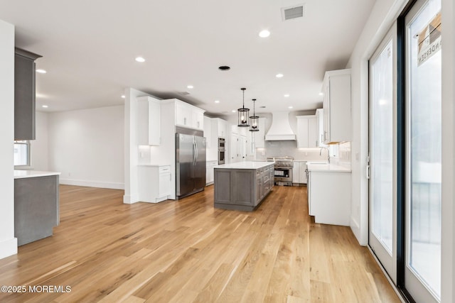 1 Foggia Way, Oceanport, NJ 07757 - kitchen with high end appliances, custom exhaust hood, a center island, light wood-style floors, and recessed lighting
