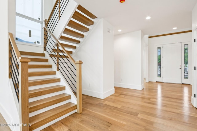 entrance foyer with baseboards, stairs, wood finished floors, and recessed lighting