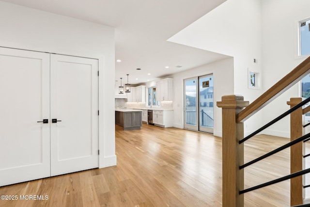 entryway featuring light wood-style flooring, stairway, and recessed lighting