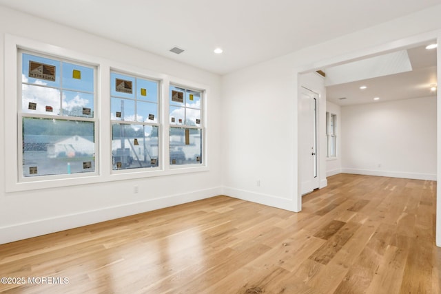 empty room featuring light wood-type flooring, baseboards, and recessed lighting