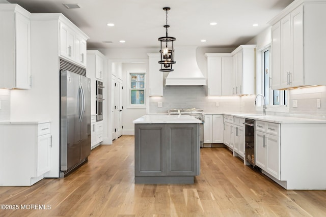 kitchen featuring appliances with stainless steel finishes, custom exhaust hood, recessed lighting, backsplash, and a sink