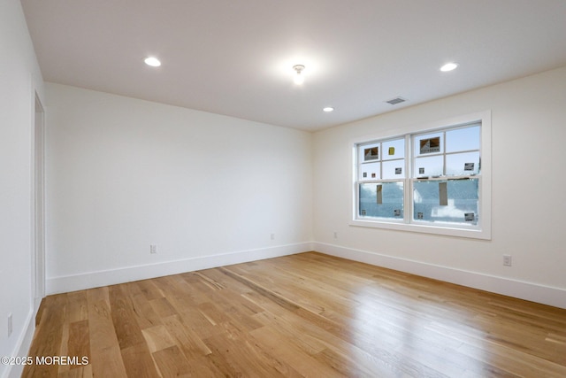 unfurnished room featuring light wood-style flooring, baseboards, and recessed lighting