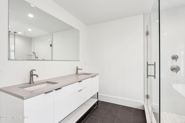 bathroom featuring a stall shower, recessed lighting, tile patterned flooring, double vanity, and baseboards