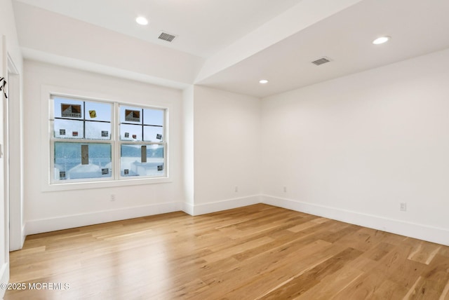 spare room with light wood-type flooring, baseboards, and recessed lighting