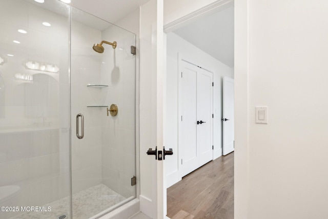 bathroom featuring a stall shower, wood finished floors, and recessed lighting