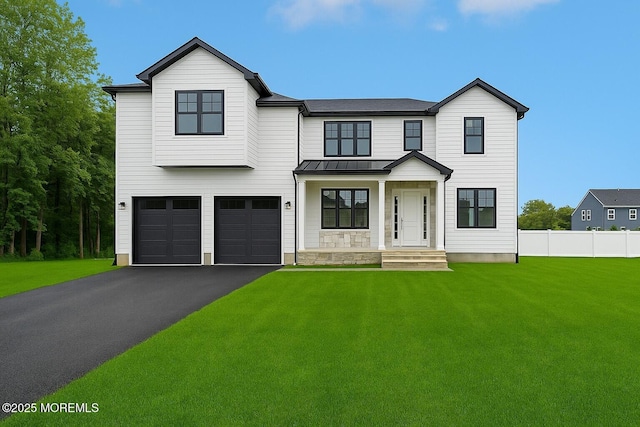 modern inspired farmhouse with a standing seam roof, asphalt driveway, an attached garage, and metal roof