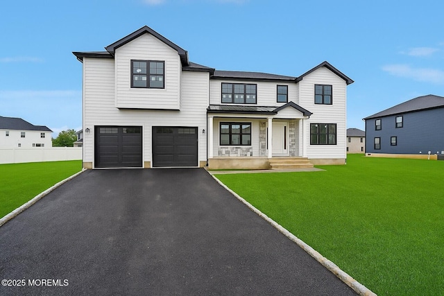 modern inspired farmhouse with a standing seam roof, an attached garage, covered porch, driveway, and metal roof
