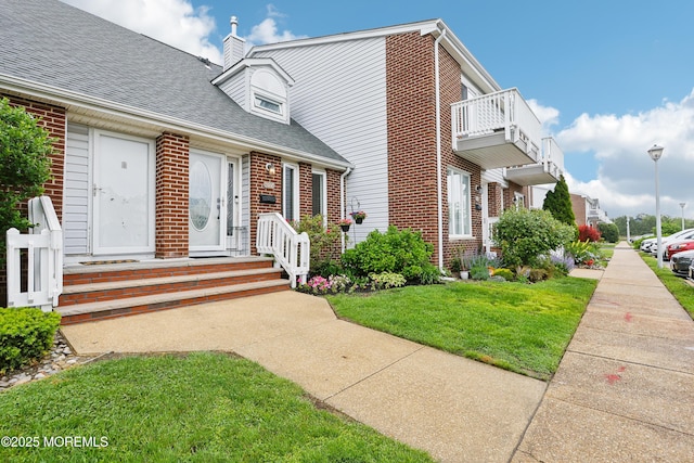 25 Meadow Ave Unit 30, Monmouth Beach, NJ 07750 - view of front of home with brick siding, a front yard, a shingled roof, and a chimney