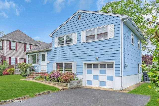tri-level home with an attached garage, a front yard, and driveway