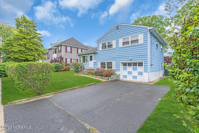 view of front of house with an attached garage, driveway, and a front yard
