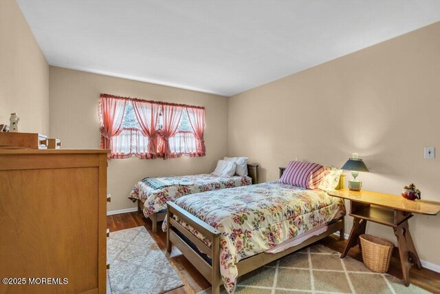 bedroom with baseboards and wood finished floors