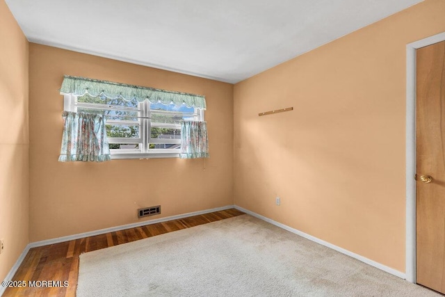 unfurnished room with baseboards and wood finished floors